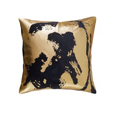 a gold and black pillow with an abstract design on the front, sitting against a white background