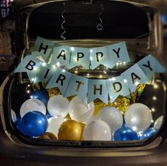 the trunk of a car with balloons and streamers in it that say happy birthday