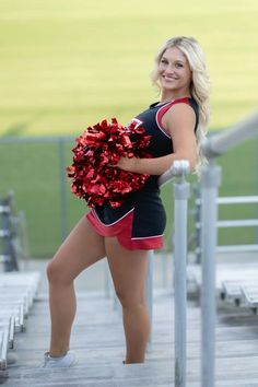 a cheerleader is posing on the bleachers with her pom - poms