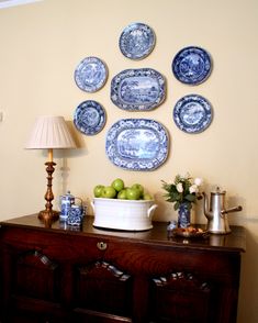 blue and white plates mounted on the wall above a buffet