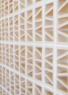 a close up view of a wall made out of white plastic bricks with geometric designs