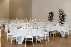 a room filled with tables and chairs covered in white tablecloths