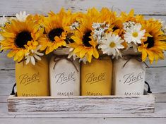 three mason jars with sunflowers and daisies in them are sitting on a shelf