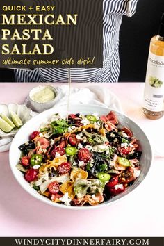 a bowl of salad next to a bottle of wine and an advertisement for mexican pasta salad