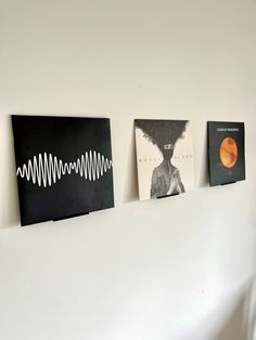 three black and white pictures hanging on the wall next to each other with sound waves