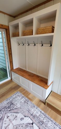 a room with a rug and some white cabinets