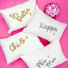 three pillows that say happy new year and one saying happy new year on them, sitting next to a pink background