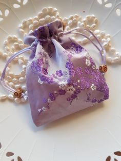 These are Gorgeous Lux silk bags in a beautiful shade of Soft Mauve, they feature a Lovely Cherry Blossom design stitched in beautiful Purples and White tones, truly elegant. The silk bags are lined inside and have a Satin draw string which makes them easy to use, and they have two nice wooden beads as a feature. The bags are approximately 11.5cm Wide and 14.5cm in length. There maybe slight variation in size of the bag and placement of the beautiful print as these were handmade. The Silk fabric is Beautiful and Lush and are perfect to elevate your Gift giving. Purple Embroidered Bag For Gift, Elegant Purple Bag Gift, Elegant Potli Bag For Gifts, Cherry Blossom Design, Silk Bag, Blossom Design, Drawstring Pouch, Coin Purses, Purse Pouch