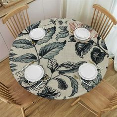 the table is set with white plates and place settings for four people to sit at