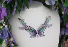 A must-have for all fairies! A truly beautiful transparent purple statement necklace, adorned with gems and a dash of sparkle. The wings are backed with wire for support and to keep their lovely shape. The necklace measures approximately 12cm across. This delicate array of fairy wings is really rather lovely. It is perfect for all fairy lovers - whether to be worn as part of a costume, or simply as a statement necklace for everyday wear. It is super light weight, and flexible to touch (please don't bend, however!) Please note that the wings may grow cloudy/opaque over time when exposed to sunlight, heat, perspiration and makeup. The wings should also avoid contact with water.  The chain measures approximately 17 inches in length. However, the chain can be made longer or shorter if you wish Purple Whimsical Necklace For Party, Whimsical Purple Necklace For Party, Fairycore Purple Necklace For Gift, Purple Fairycore Jewelry For Party, Iridescent Fairy-style Jewelry For Parties, Iridescent Fairy Jewelry For Parties, Iridescent Fairy Style Jewelry For Party, Fairycore Butterfly Necklace Gift, Purple Statement Necklace