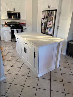 a kitchen with white cabinets and tile flooring