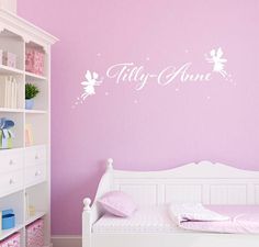 a white bed sitting under a pink wall next to a book shelf with books on it