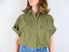 "Vintage cargo pocket cotton short sleeve button down shirt from the 90s.  Features a 2\" pointed collar and seven buttons down center front.  Has a boxy silhouette with a curved hemline that's shorter in the front than in the back, boxy half sleeves and 6\"x 6.5\" cargo style front chest pockets with flap top closures.  Made of an army /olive green lightweight woven cotton material.  Looks great worn buttoned up, open and layered, tucked in or tied up.  A classic piece that will never go out of Safari Shirt, Coord Set, Cargo Shirts, Cargo Style, Women Cargos, Cargo Pocket, Pocket Shirt, Woven Cotton, Crop Shirt