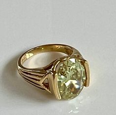 "Stunning 925 gold-plated size 7 ring with magnificent oval light green gemstone. The gold-plating is high polished and smooth. The green gemstone is catches the light and sparkles. The gemstone approximately measures 9/16\" in length and 6/16\" (1/2\")  in width.  Love the unusual setting. The ring is in excellent condition and is stamped UTC 925. Total weight 6.42 grams. Thank you for looking and shopping with Betty Jo! Questions? We are happy to help. Please look at all our other designer and Gold Oval Ring With Large Stone, Gold Oval Emerald Ring For Formal Occasions, Formal Gold Emerald Oval Ring, Gold Oval Emerald Gemstone Ring, Gold Emerald Ring With Oval Gemstone, Gold Emerald Ring With Large Oval Stone, Elegant Gold Emerald Ring With Large Stone, Green Oval High Luster Jewelry, Green Gemstones