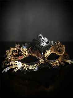 This mask has a luxurious black finish with shining gold metal and is adorned with radiant topaz rhinestones. This mask is designed for hours of wear, so you can dance the night away without worry. Whether you're dancing under the stars at a glamorous ball or making a grand entrance at a themed event, our mask will turn heads and leave a lasting impression.


Age Group/Gender - Adult/Women

Size/Type - One size fits all adults

Mask Color - Black/Gold

Mask Material - Polyresin/Metal Luxury Gold Masquerade Mask For Carnival, Traditional Luxury Gold Masquerade Mask, Luxury Traditional Gold Masquerade Mask, Luxury Gold Masks And Prosthetics For Parties, Luxury Gold Mask For Masquerade, Luxury Gold Masquerade Mask For Theater, Luxury Black Masks And Prosthetics For Fantasy Events, Luxury Black Theater Masks, Black And Gold Masquerade Dress And Mask