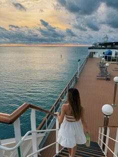 a woman walking up the stairs to a cruise ship at sunset or dawn with dark clouds in the background