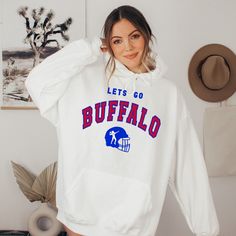 Buffalo Womens Sweatshirt, Buffalo Football Hoodie, Vintage Buffalo Sweatshirt, Retro Buffalo Football Crewneck, Buffalo Hoodie Women This is the perfect hoodie for keeping warm in style. This crewneck is knit using tubular knit, which reduces fabric waste and makes your piece look better than ever! The ribbed knit collar adds an extra bit of flare to this piece, making it look highly elastic and helping it retain its shape. This product is SUPER soft and SUPER comfy, so it's perfect for tailgat White College Fan Apparel Hoodie, White Fleece Hoodie For Fan Gear, White Hooded Sweatshirt For Game Day, White Hoodie With Ribbed Cuffs For Game Day, White Hooded Sweatshirt For Fan Gear, White Fleece Hoodie With Team Name, White Team Spirit Hoodie Sweatshirt, White Fan Apparel Hoodie Sweatshirt, Pre-shrunk White Hoodie Sweatshirt