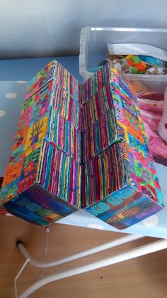 a colorful box sitting on top of a table next to a pair of white scissors