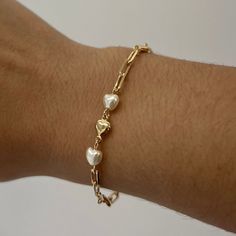 The Lauren Heart Bracelet is a unique symbol of love, style & sophistication. Integrated throughout the bracelet are gold & pearl hearts. The lustrous pearls exude purity and grace, while the gold hearts radiate warmth & timeless beauty. The Lauren Heart Bracelet captures the essence of love & peace. Product Details: 18K Gold-Filled Pearl & Heart Paperclip Bracelet Two Pearl Accents Not Water-Wearable Made in Scottsdale, AZ Heart Paperclip, Paperclip Bracelet, Unique Symbols, Symbol Of Love, Gold Hearts, Pearl Heart, Love Style, Solid Gold Jewelry, Scottsdale Az