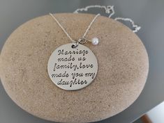 1.25" disk stamped with "Marriage made us family, love made you my daughter". Item is only 1 sided. Stamping on the back is not possible. Comes with pearl charm. Comes on a 16", 18" or 20" sterling chain. Please feel free to message me with any questions you may have.  PLEASE make sure you leave the details with your order. If you send me a separate message with custom details it may get overlooked.  Hand stamping jewelry involves a piece of metal, a stamp, a hammer, and me. Please be aware that this is not etched with a machine and there will be variances in spacing, depth and alignment with each letter.  Production time varies depending on the time of year. I make every attempt to ship orders within one week, however; during busier times of the year it may be closer to 2 weeks. Please ma Stamped Necklaces For Wedding And Mother's Day, Hand Stamped Round Wedding Necklaces, Hand Stamped Round Necklaces For Wedding, Wedding Necklace For Mother's Day, Wedding Necklaces For Mother's Day, Hand Stamped Necklace For Wedding On Mother's Day, Hand Stamped Necklaces For Wedding/mother's Day, Stamped Round Necklace For Wedding, Round Stamped Necklaces For Weddings