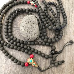 Everyday black lava stone mala necklace. You can choose between 2 styles. 1- A Mala necklace that is all black lava stones which is 43cm- 17 inch long (there is no clasp, you wear it over the head) 2-A Mala necklace which has black lava stones, red beads and unique Nepali beads. This Mala is 48cm- 19 inch long ( there is no clasp, you wear it over your head) This unique unisex mala necklaces can be a diffuser necklaces also, as you can choose which ever oil that you like to use with the lava roc Holistic Black Round Beaded Jewelry, Holistic Black Round Beads Jewelry, Handmade Black Mala For Meditation, Handmade Black Mala As Gift, Black Natural Stones Beads For Meditation, Black Mala With Round Beads For Gift, Spiritual Black Beads Necklace For Meditation, Spiritual Black Beaded Necklaces For Meditation, Black Beaded Mala As A Gift