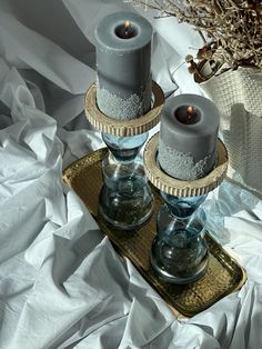 two candles sitting on top of a tray