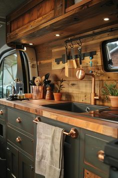 a kitchen area with sink, cabinets and television in the back ground is decorated with wood planks