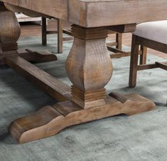 a wooden table with two chairs and a bench in the middle on a carpeted floor