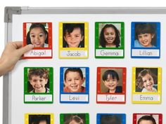 a child's hand holding up a white board with pictures of children on it