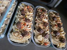 three tins filled with different types of desserts on top of a table next to each other