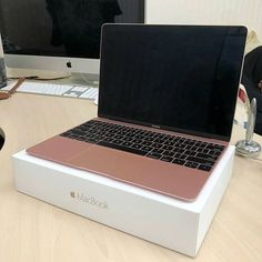 an open laptop computer sitting on top of a wooden desk next to a mouse and keyboard