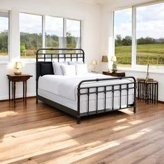 a bedroom with hardwood floors and large windows