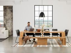 a man sitting at a table using a laptop