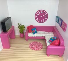 a toy living room with pink furniture and a clock on the wall above the couch