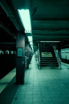 an empty subway station with stairs leading up to it