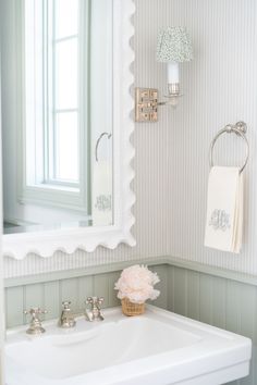 a bathroom with a sink, mirror and towel rack