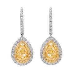 Stunning yellow diamond and diamond halo drop earrings, by Alexander Beverly Hills. 2.74 carats total diamond weight. 2 pear shape diamonds, 2.01 carats total. Approximately Fancy Light Yellow color grade and SI clarity grade. Complimented by 39 round brilliant cut diamonds, 0.26 carats. Approximately Fancy Light color and SI clarity. Complimented by 71 round brilliant cut diamonds, 0.47 carats. Approximately G/H color and SI clarity. 18k white and yellow gold, 5.07 grams, 1 inches. Accommodated Light Yellow Color, Fancy Light, Colorless Diamond, Yellow Stone, Diamond Drop Earrings, Diamond Drops, Pear Shaped Diamond, Diamond Halo, Yellow Diamond