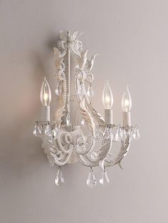 a white chandelier hanging from the side of a wall