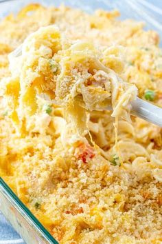 a casserole dish filled with macaroni and cheese is being lifted by a spoon