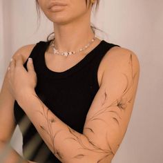 a woman with tattoos on her arms and armbands is posing for the camera