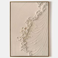 an abstract painting with white paint and gold trimmings on a beige background, framed in wood frame