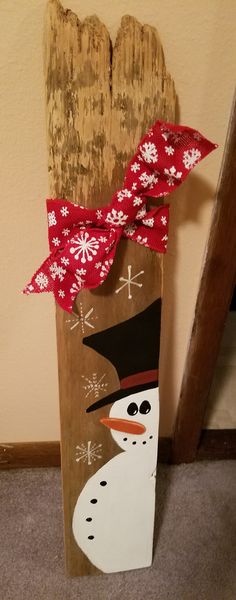 a wooden sign with a snowman painted on it