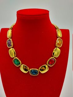 "This gleaming gold plated necklace is from iconic Napier, 1991 \"Royalton\" series, in Excellent condition ready to impress! It showcases Swarovski crystal rhinestones in rectangular settings~~emerald green, ruby red, golden amber, amethyst purple, and sapphire blue. It is signed on the fold over closure and in back, and measures 17\" long by 7/8\" wide. A glorious tribute to the unrivaled quality and impeccable styling of Napier, a company with well-deserved Collectible status!" Evening Multi-stone Yellow Gold Jewelry, Evening Yellow Gold Multi-stone Jewelry, Yellow Gold Multi-stone Jewelry For Evening, Gold Hallmarked Necklaces For Evening, Vintage Gold Multi-stone Necklace, Luxury Jeweled Yellow Gold Necklace, Luxury Jeweled Necklaces For Formal Occasions, Luxury Yellow Gold Jeweled Necklace, Luxury Jeweled Necklace For Formal Occasions