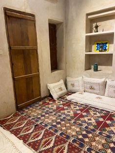 a room with a bed, bookcases and rug on the floor in front of it