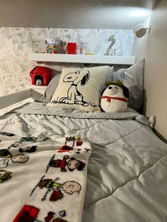 there is a bed with snoopy pillows on it