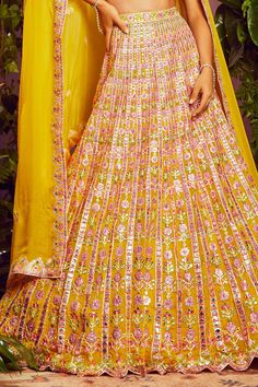 Yellow organza lehenga with all-over floral motif mirror-foil applique work and vertical striped detail. Comes with embroidered blouse and dupatta.
Component: 3
Embroidered
Neckline: V Neck
Sleeve Length: Sleeveless
Fabric: Soft Organza; Lining: Shantoon
Color: Yellow
Cutwork detail
V- back - Aza Fashions Multicolor Gota Work Lehenga For Transitional Season, Yellow Georgette Gown For Diwali, Chanderi Wedding Set Floor-length, Wedding Chanderi Floor-length Sets, Floor-length Chanderi Wedding Sets, Multicolor Cutdana Dress For Wedding, Bollywood Style Yellow Reception Dress, Multicolor Cutdana Wedding Dress, Yellow Wedding Dress With Dupatta