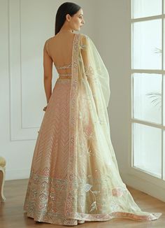 Features a soft pastel pink organza lehenga with heavy mirror work and gota patti embroidery. Styled with a strappy organza embroidered blouse and an elegant dupatta with mirror work and gota patti detailing. Included in the set is the embroidered belt that completes the ensemble Composition : Organza And Net Care: Dry Clean Only and Vacuum Storage This product can be customised for sleeves, length of blouse and neckline Delivery : 6-8 weeks as the product is hand crafted. For more information and sizes please contact fabiliciousfashion@gmail.com or visit our Copenhagen studio. Peach Sets With Mirror Work For Reception, Peach Reception Set With Mirror Work, Peach Reception Sets With Mirror Work, Pink Dola Silk Gown With Dori Work, Pink Organza Choli With Gota Work, Pink Organza Choli With Dori Work, Pink Organza Choli With Dupatta, Peach Choli With Sheer Dupatta For Weddings, Floor-length Organza Saree With Gota Work