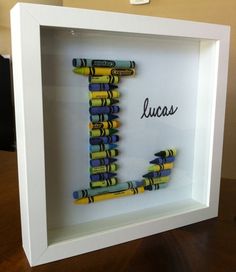 the letter j is made out of crayons in a shadow box with writing on it