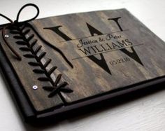 a personalized wooden book with baseball stitches on it and the initials at the bottom