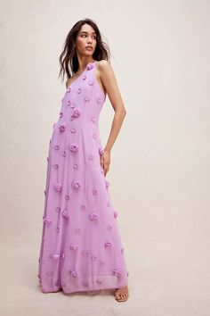 a woman wearing a purple dress with flowers on it